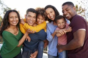 An intergenerational family smiling now they know the importance of critical illness insurance, life insurance, lasting power of attorney and making a will.