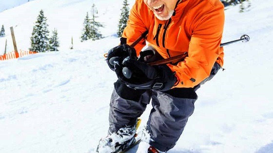 Older man enjoying skiing in a bright orange jacket after not exceeding his lifetime allowance