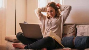 Women on laptop thinking about retiring from work and not a paycheck