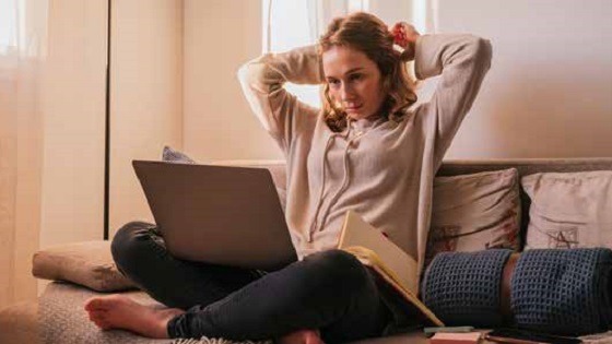 Women on laptop thinking about retiring from work and not a paycheck