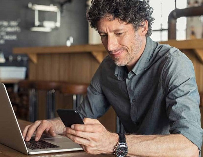 A man checking his SIPP on his laptop and phone