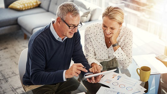 A mature couple looking at paperwork to for see if they can take early retirement